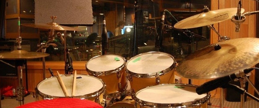 A picture of a drumset and Jon Zacks in the background